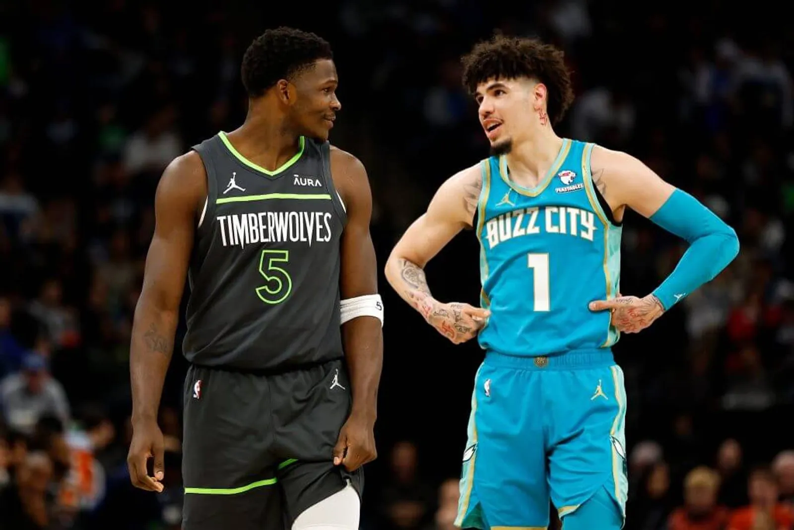 Anthony Edwards stands next to LaMelo Ball — who has his hands on his hips — as Ball talks to him on the court.