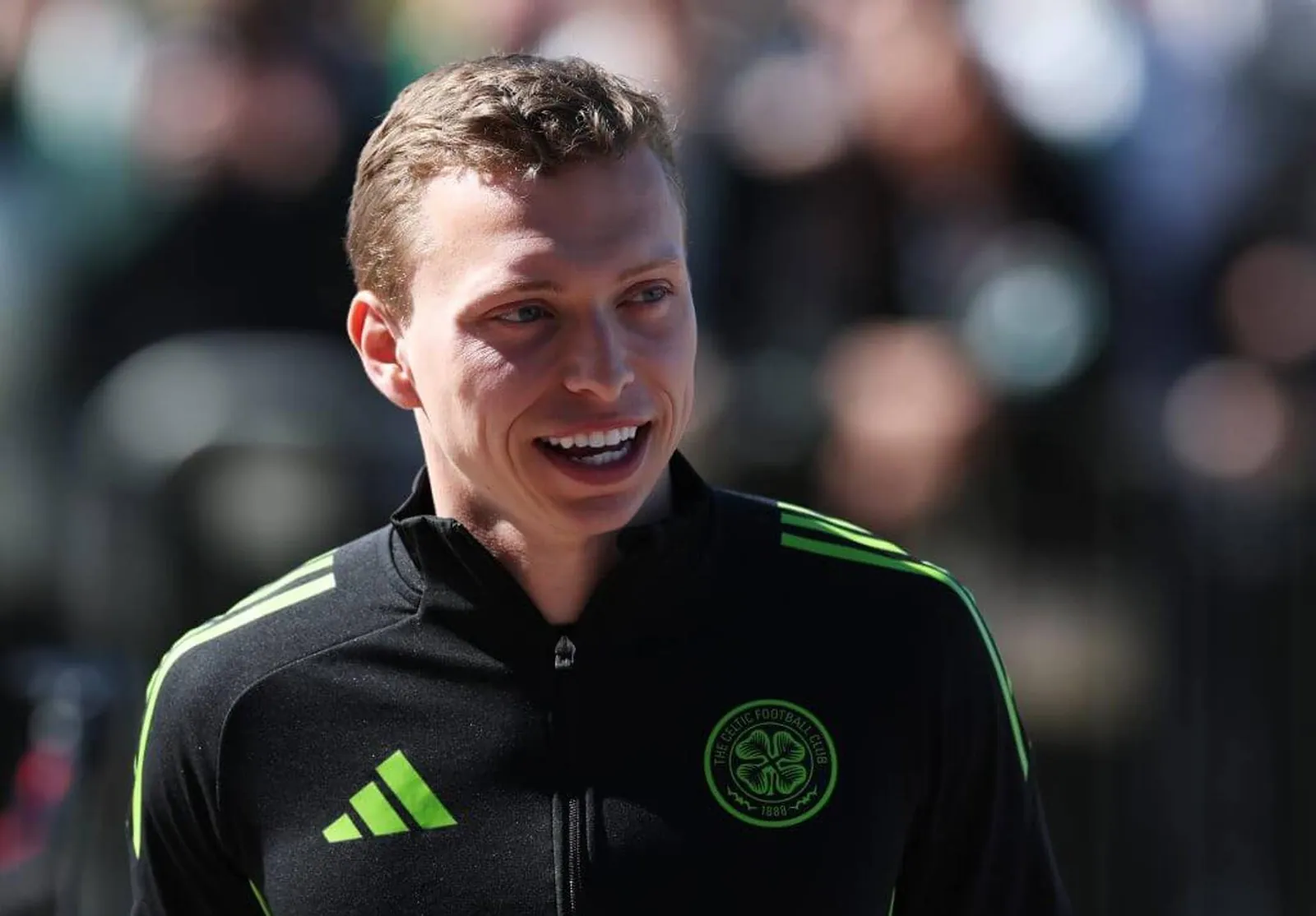 Alistair Johnston looks on smiling while warming up for Celtic