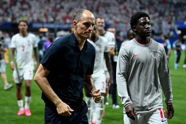 ATLANTA, GEORGIA - JULY 15: Thomas Tuchel, Manager of England, walks off the pitch with Kobbie Mainoo #16 after the 1-2 loss during the FIFA World Cup 2026 Semi Final match between England and Argentina at Atlanta Stadium on July 15, 2026 in Atlanta, Georgia. (Photo by Shaun Botterill/Getty Images)